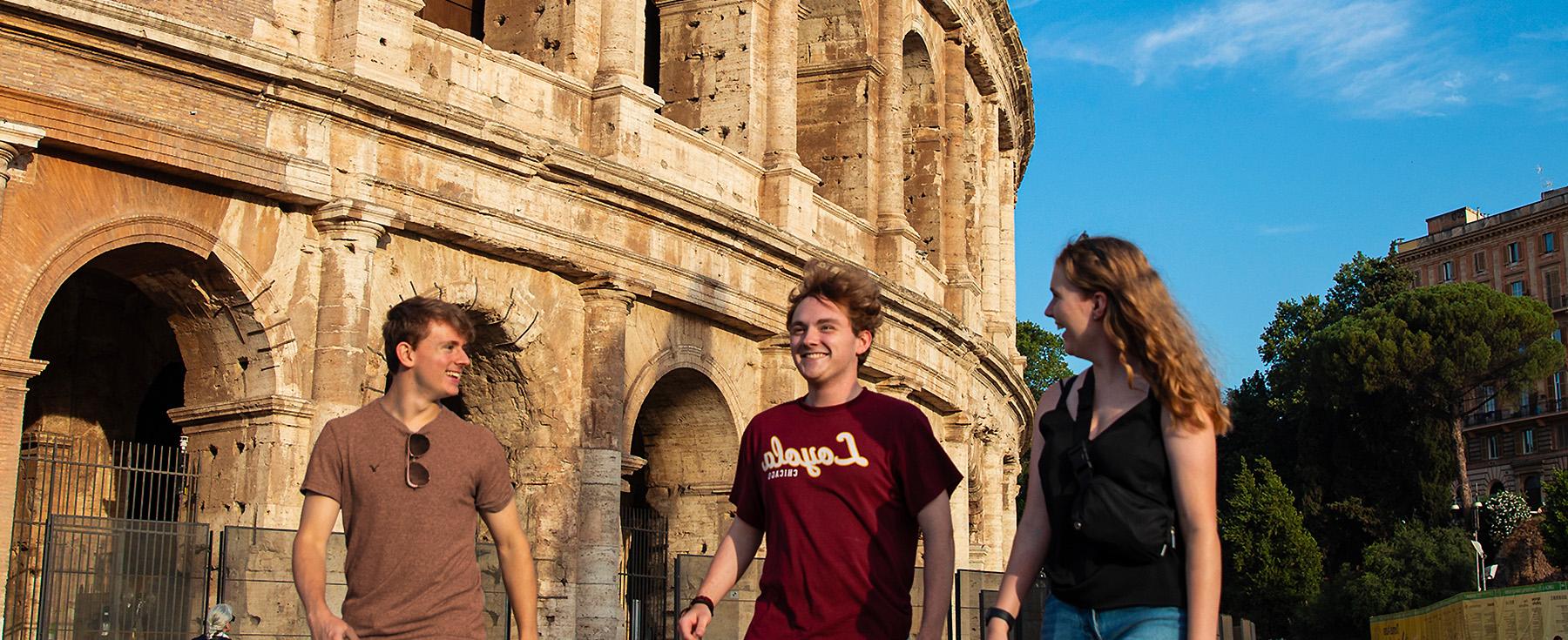 博彩平台的学生走在标志性的罗马竞技场旁边